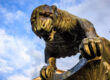 Bronzestatue des Bahkauv, der Aachener Fabelkreatur, Nahaufnahme des Kopfes vor blauem Himmel.