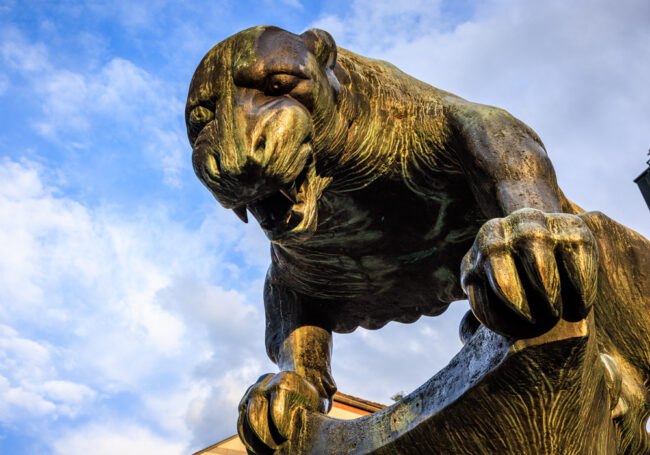 Bronzestatue des Bahkauv, der Aachener Fabelkreatur, Nahaufnahme des Kopfes vor blauem Himmel.