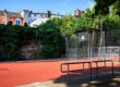 Basketballplatz im Soermondtpark in Aachen mit Ballfangzaun, umgeben von Wohnhäusern und Grünflächen.