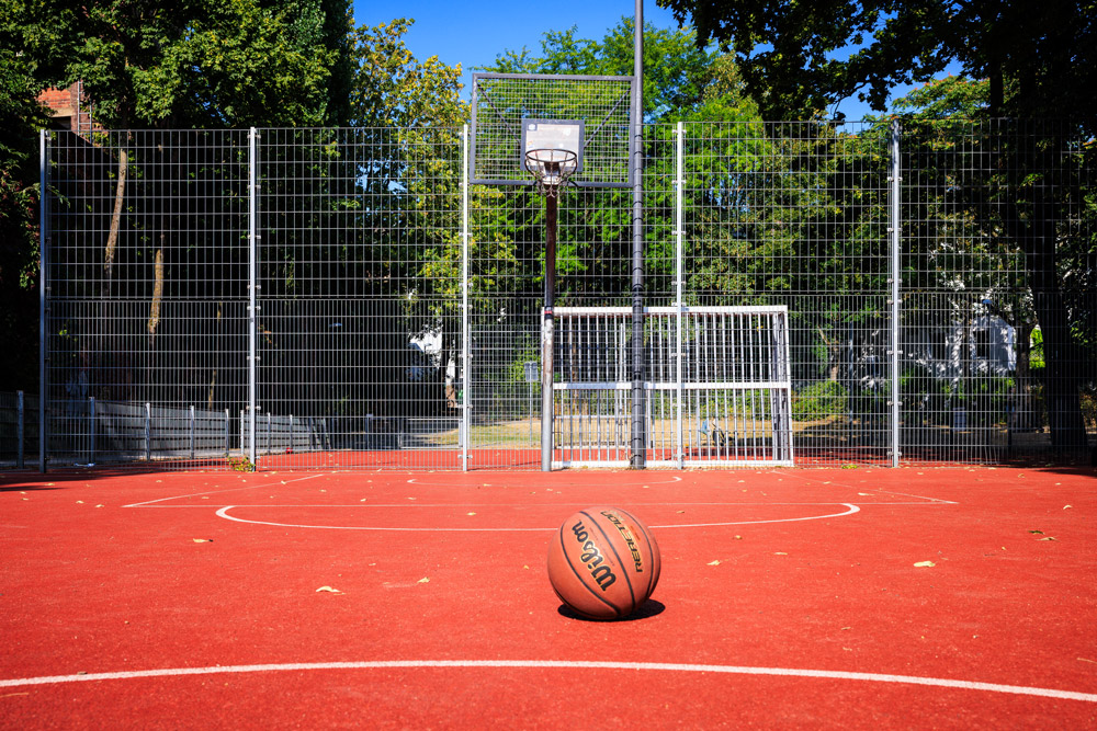 Basketball auf dem Streetball-Platz im Soermondtpark in Aachen, im Hintergrund Korb und Netz.