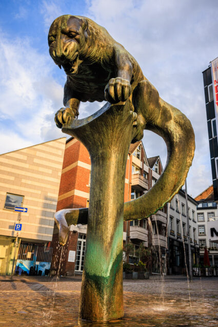 Der Bahkauvbrunnen am Büchel in Aachen, die Bronzefigur auf der Wassersäule des Brunnens.