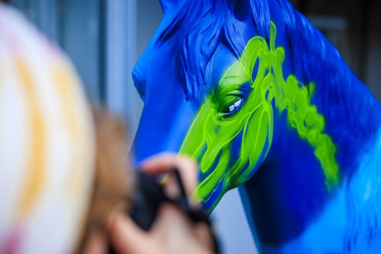 Detailaufnahme eines blau-grün bemalten Pferdemodells beim Airbrushen im Rahmen des CHIO Aachen