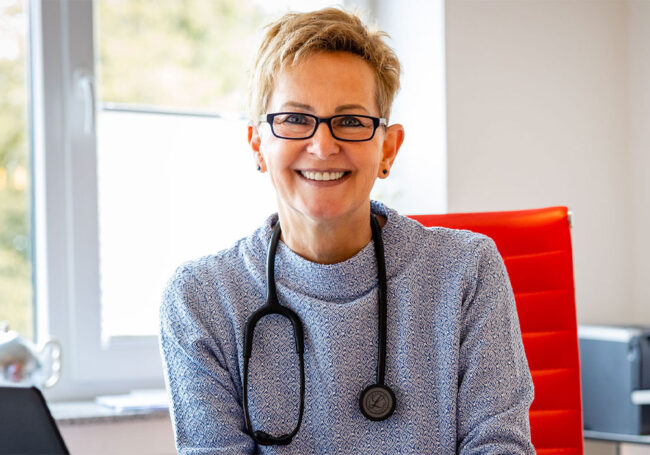Porträt von Angelika Sailer, Hausärztin in Aachen-Soers, mit Stethoskop in ihrer Praxis