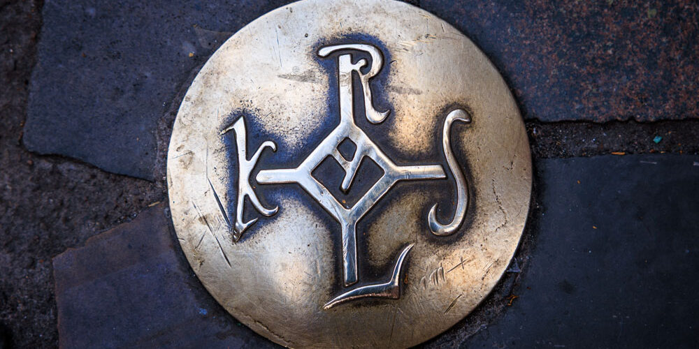 Bronzenagel mit dem Karolus-Monogramm im Kopfsteinpflaster der Aachener Altstadt