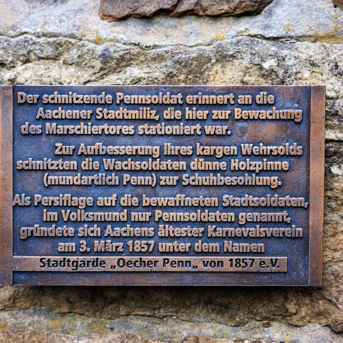 Bronzetafel am Marschiertor mit der Geschichte des Pennsoldaten und der Gründung der Stadtgarde Oecher Penn von 1857
