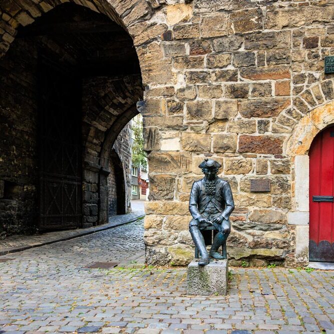 Bronzestatue eines sitzenden Pennsoldaten vor dem Torbogen des Marschiertors, daneben eine rote Tür