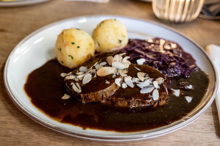 Öcher Sauerbraten im Postwagen Zum Ratskeller: geschmorte Rinderscheibe mit gerösteten Mandelblättchen, dazu zwei Kartoffelklöße und Apfelrotkohl