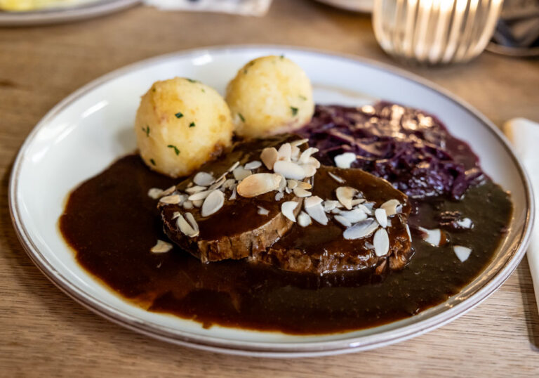 Öcher Sauerbraten im Postwagen Zum Ratskeller Öcher Sauerbraten im Postwagen Zum Ratskeller: geschmorte Rinderscheibe mit gerösteten Mandelblättchen, dazu zwei Kartoffelklöße und Apfelrotkohl