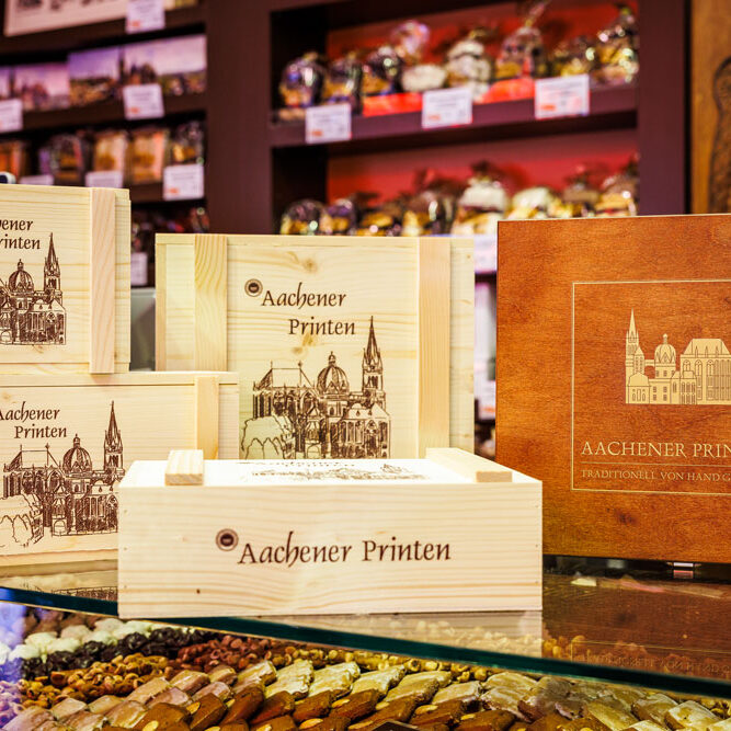 Holzkisten mit „Aachener Printen"-Aufdruck und Dom-Motiv bei Printen Klein, ideal als Geschenk oder Mitbringsel
