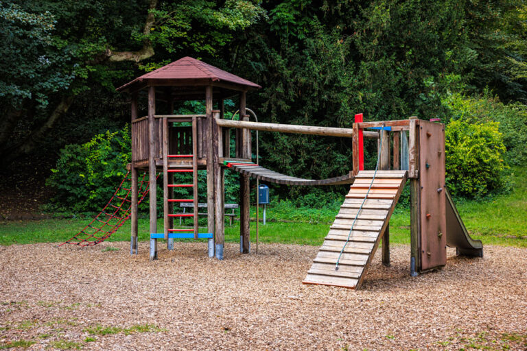 Hölzerne Kletteranlage am Spielplatz Buchenallee mit Spielturm, Hängebrücke, Kletterwand und Rutsche