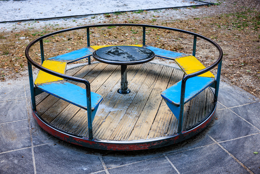 Buntes Drehkarussell mit Sitzbänken am Spielplatz Buchenallee