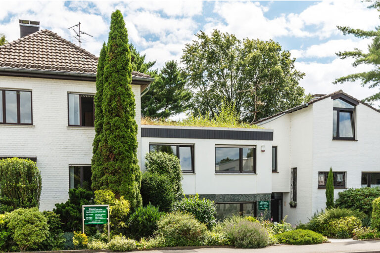 Kanzleigebäude von Steuerberater Capellmann und Partner mbB in Herzogenrath, weißes Wohn- und Bürohaus mit begrüntem Dach und gepflegtem Vorgarten