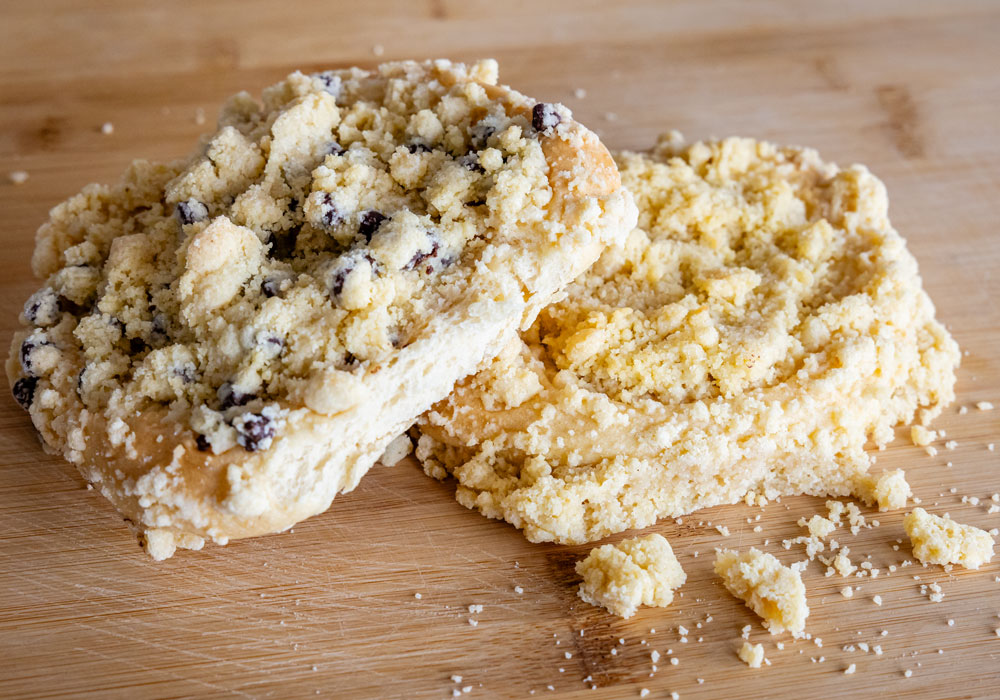 Aachener Streuselbrötchen im Vergleich: Schokostreuselbrötchen mit Schokoladenstückchen und klassisches Streuselbrötchen nebeneinander auf Holzbrett