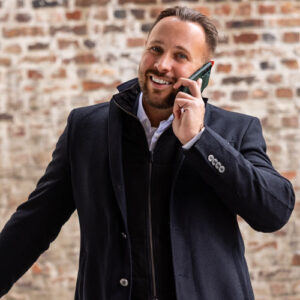Stephan Jansen, Gründer von KTL Immobilien, im Mantel telefonierend vor einer Backsteinwand