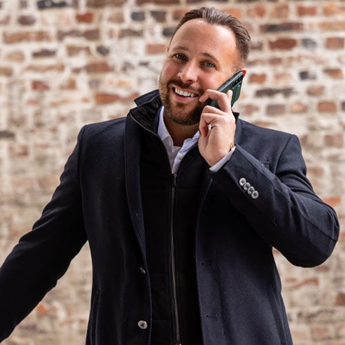 Stephan Jansen, Gründer von KTL Immobilien, im Mantel telefonierend vor einer Backsteinwand